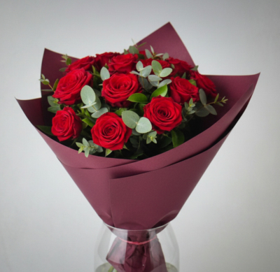 Bukiet Królowa Wieczoru z czerwonych róż w bordowym papierze.
